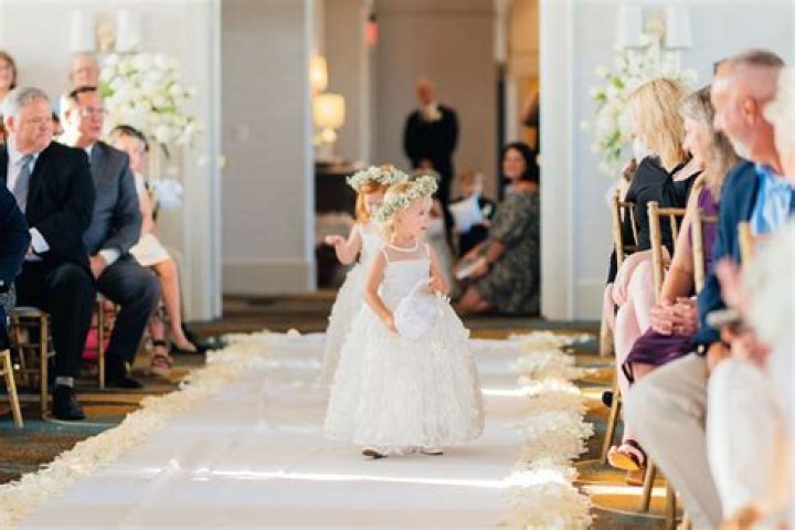 Who walks the flower girl down the aisle?